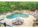 Beautiful kidney-shaped pool with a rock waterfall, surrounded by palm trees and lounge chairs at 95 Weslyan Way, Oxford, GA 30054