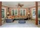 Inviting sunroom features brick walls, neutral furniture, and a ceiling fan at 95 Weslyan Way, Oxford, GA 30054