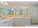 Bright bathroom featuring a double vanity, large mirror, and neutral tile flooring at 1777 E Gate Trl, Stone Mountain, GA 30087