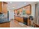 A warm kitchen boasts granite counters, wooden cabinets and stainless steel appliances over hardwood floors at 1777 E Gate Trl, Stone Mountain, GA 30087