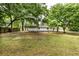 Large grassy backyard showing the back of the house, a slab, and ample space for outdoor activities at 3978 Oglesby Rd, Powder Springs, GA 30127