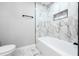 Bright bathroom featuring marbled tile, a soaking tub and a toilet at 3978 Oglesby Rd, Powder Springs, GA 30127