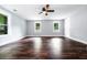 Bright living room with hardwood floors, ceiling fan and two windows overlooking a lush landscape at 3978 Oglesby Rd, Powder Springs, GA 30127