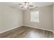 Neutral bedroom with wood look floors, ceiling fan, and a window at 4248 Wellington Hills Ln, Snellville, GA 30039