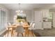 Staged dining room with wooden table, white chairs, and modern chandelier at 4248 Wellington Hills Ln, Snellville, GA 30039