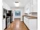 Well-lit kitchen with stainless steel appliances, white cabinets, and wood flooring throughout at 2786 Olde Gate Ct, Snellville, GA 30078