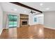 Open-concept living room with a stone fireplace, vinyl flooring, and a sliding door to the backyard at 2786 Olde Gate Ct, Snellville, GA 30078
