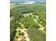 Aerial view of a sprawling property, showcasing mature trees, winding roads, and a glimpse of the surrounding landscape at 4841 Partee Trl, Social Circle, GA 30025