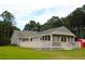 Back exterior view, featuring a deck, screened porch and a red storage shed at 4841 Partee Trl, Social Circle, GA 30025