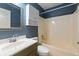 Bathroom featuring a classic vanity, bathtub-shower combo and blue accent wall for a cozy and inviting space at 4841 Partee Trl, Social Circle, GA 30025