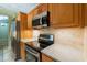Modern kitchen equipped with stainless appliances, stone countertops, and light wood cabinets at 4841 Partee Trl, Social Circle, GA 30025