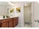A bathroom with dark wood cabinets, double sinks, a large mirror, and a view into the shower/tub at 667 Creswell Park, Smyrna, GA 30082