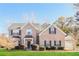 Traditional brick home featuring a manicured lawn, mature landscaping, and an attached two-car garage at 122 Melrose Creek Dr, Stockbridge, GA 30281