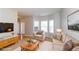The living room is virtually staged with modern furniture, a TV, and a view of the bay windows at 122 Melrose Creek Dr, Stockbridge, GA 30281
