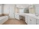Bright bathroom with double vanity, white cabinets, and a separate bathtub and shower space at 251 Sumac Trl, Woodstock, GA 30188