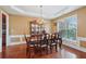 Elegant dining room featuring hardwood floors, a decorative chandelier, and classic wainscoting details at 251 Sumac Trl, Woodstock, GA 30188