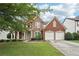 Charming two-story brick home features a manicured lawn, a two-car garage, and mature shade trees at 251 Sumac Trl, Woodstock, GA 30188
