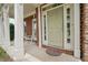 Inviting front porch with white columns, a rocking chair, and a decorative rug at the front door at 251 Sumac Trl, Woodstock, GA 30188