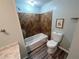 Bathroom featuring a tub with tiled surround and a modern toilet at 2691 Old South Dr, Jonesboro, GA 30236