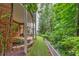 Landscaped backyard with covered patio, providing a serene outdoor retreat surrounded by lush greenery and a white fence at 3150 Seven Oaks Dr, Cumming, GA 30041