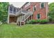Expansive backyard featuring a multilevel deck, patio, and well-manicured lawn with mature trees and landscaping at 3150 Seven Oaks Dr, Cumming, GA 30041