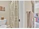 Bathroom featuring a floral shower curtain, toilet, and towel rack, and a view to a bright bedroom at 3150 Seven Oaks Dr, Cumming, GA 30041