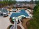 Aerial view of a community pool with water slide, splash pad, and clubhouse, all surrounded by lush landscaping at 3150 Seven Oaks Dr, Cumming, GA 30041
