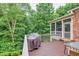 A wooden deck features a grill with a cover and backs up to dense trees at 3150 Seven Oaks Dr, Cumming, GA 30041