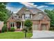 Charming two-story home with a well-manicured lawn, stone and brick facade, and two-car garage at 3150 Seven Oaks Dr, Cumming, GA 30041