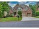 Beautiful brick and stone home featuring a two-car garage, pristine lawn, and mature landscaping at 3150 Seven Oaks Dr, Cumming, GA 30041