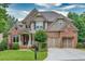 Charming two-story home with a well-manicured lawn, stone and brick facade, and two-car garage at 3150 Seven Oaks Dr, Cumming, GA 30041
