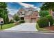 Beautiful brick and stone home featuring a two-car garage, pristine lawn, and mature landscaping at 3150 Seven Oaks Dr, Cumming, GA 30041