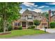 Stunning brick and stone home featuring a well-kept lawn, professional landscaping, and a two-car garage at 3150 Seven Oaks Dr, Cumming, GA 30041