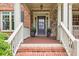 Charming front porch with brick steps, stone accents, and a stylish dark-colored front door at 3150 Seven Oaks Dr, Cumming, GA 30041