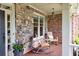 Cozy front porch with brick and stone accents, rocking chairs, and outdoor decor at 3150 Seven Oaks Dr, Cumming, GA 30041