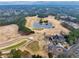 Overhead view of a lush golf course with manicured greens, sand traps, and a scenic pond, surrounded by trees at 3150 Seven Oaks Dr, Cumming, GA 30041