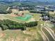 Aerial view of a golf course and pond surrounded by trees and residential developments at 3150 Seven Oaks Dr, Cumming, GA 30041