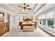 Spacious main bedroom featuring tray ceilings, carpet, a four poster bed, and large windows at 3150 Seven Oaks Dr, Cumming, GA 30041