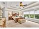 Serene main bedroom with carpet, a four poster bed, tray ceilings, and lots of natural light at 3150 Seven Oaks Dr, Cumming, GA 30041
