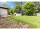 Spacious backyard with a detached garage and lush greenery at 6873 Church St, Riverdale, GA 30274