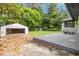 Backyard featuring a detached one-car garage, green lawn, and side yard at 6873 Church St, Riverdale, GA 30274