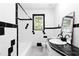 Bright bathroom featuring black and white tile, a window, and updated fixtures at 6873 Church St, Riverdale, GA 30274