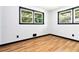 Bedroom featuring hardwood floors, neutral walls, and two windows at 6873 Church St, Riverdale, GA 30274
