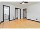 Bright bedroom featuring hard wood floors, bathroom entrance, closet, and ceiling fan at 6873 Church St, Riverdale, GA 30274