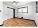 Bedroom featuring hard wood floors, neutral walls, closet, and two windows at 6873 Church St, Riverdale, GA 30274