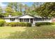 Charming, single-story home with white brick, black trim, and mature landscaping at 6873 Church St, Riverdale, GA 30274
