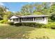 Street view of a cute ranch home with manicured front yard and mature trees at 6873 Church St, Riverdale, GA 30274