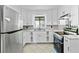 Well-lit kitchen featuring stainless appliances, white cabinets, and tile backsplash at 6873 Church St, Riverdale, GA 30274