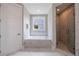 Bathroom with a soaking tub, a glass shower, and natural light from a window at 130 Lapis Lake Pt, Fayetteville, GA 30215