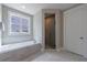 Well-lit bathroom with a tub, shower, and window offering natural light at 130 Lapis Lake Pt, Fayetteville, GA 30215